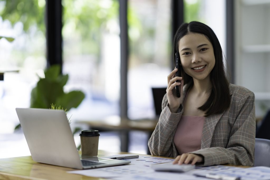 Portrait of young successful beautiful Asian businesswoman sitting at a desk at home office work on